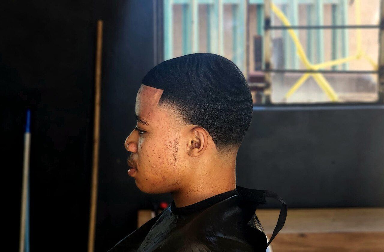 Jovem com corte degradê na cadeira